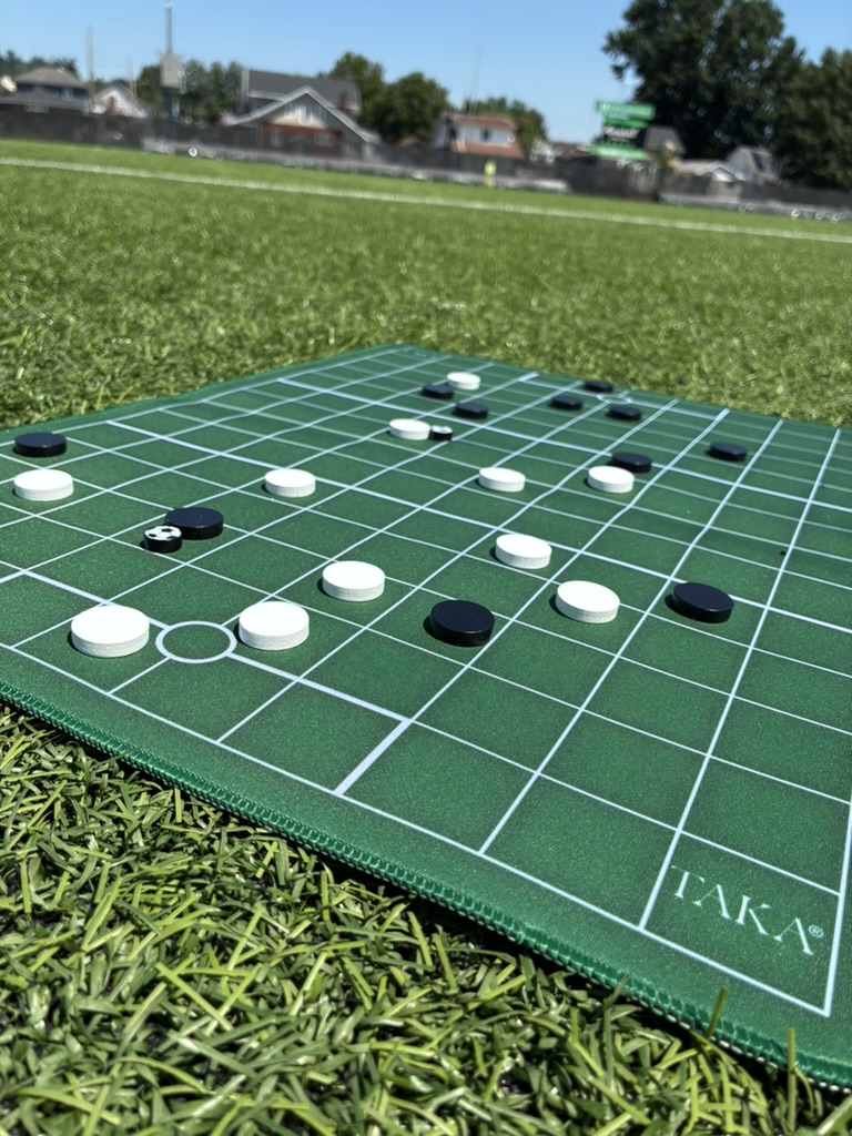 The Taka board set up pitchside on a football field, a game in progress